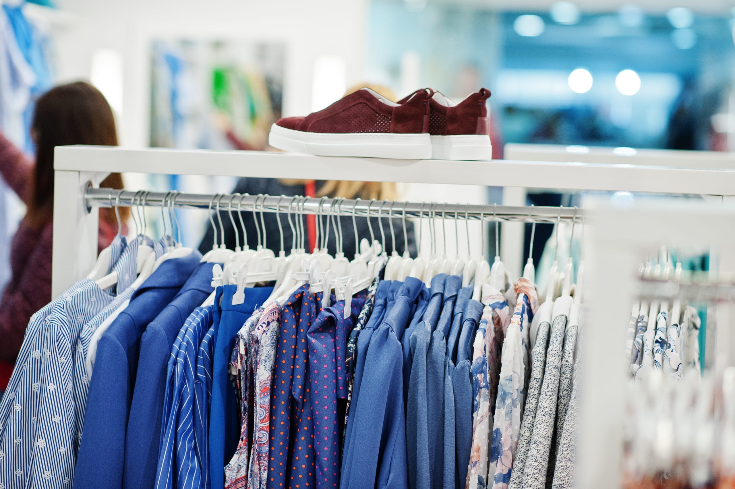Female colorful clothing set of on the racks with shoes in cloth